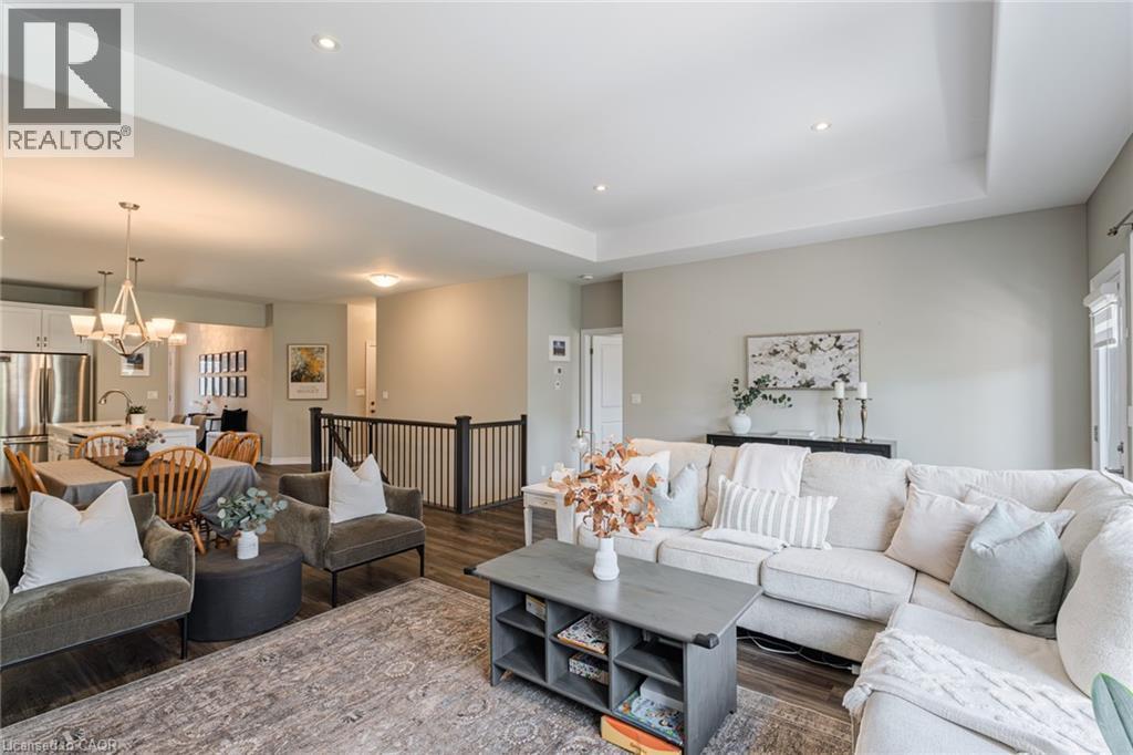 Spacious open-concept living area featuring wood-finish flooring and recessed lighting - 15 Winterberry Lane, Waterford, ON