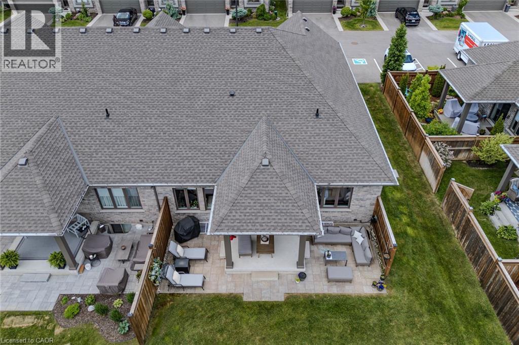 Expansive backyard featuring a manicured lawn and two distinct patio areas - 15 Winterberry Lane, Waterford, ON
