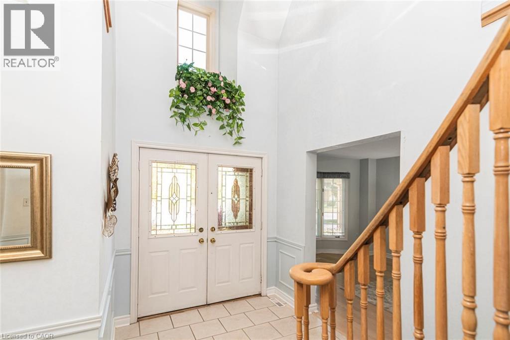 Grand entryway featuring a double door with decorative glass inserts, a transom window, and a two-story ceiling - 85 Citation Crescent, Ancaster, ON