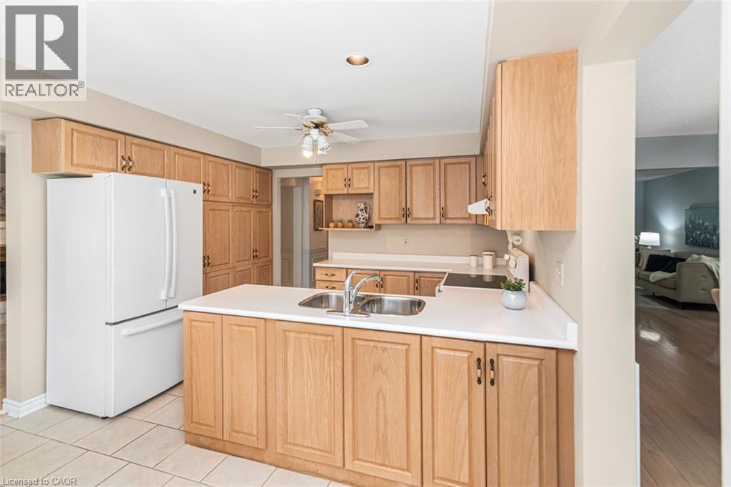 Kitchen featuring light-tone wood cabinetry, recessed lighting, and a center island with a double basin sink - 85 Citation Crescent, Ancaster, ON