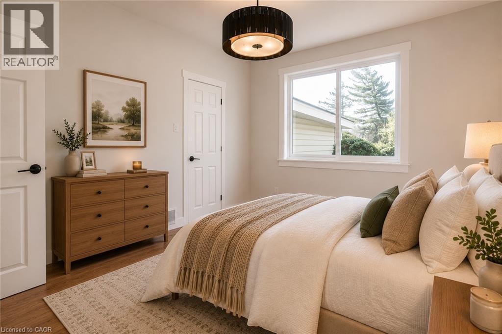 Spacious room featuring wood-finish flooring, a contemporary ceiling light fixture, and white trim - 204 Glow Avenue Unit# Upper, Hamilton, ON
