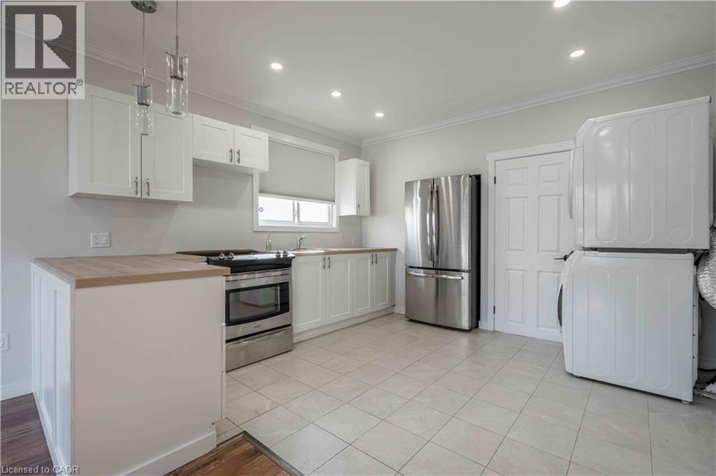 Kitchen featuring white cabinetry, light wood-finish countertops, stainless steel appliances, and recessed lighting - 204 Glow Avenue Unit# Upper, Hamilton, ON