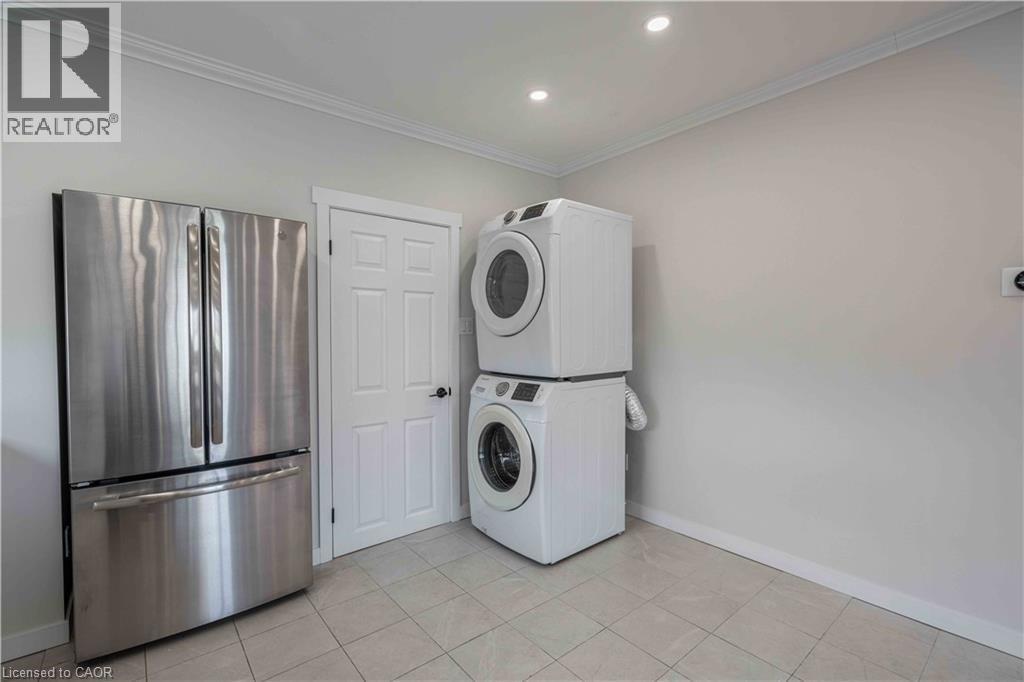 Laundry area featuring tile flooring, white baseboards, and crown molding - 204 Glow Avenue Unit# Upper, Hamilton, ON