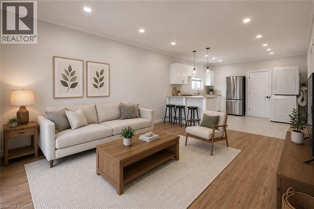 Open-concept living space featuring wood-finish flooring, recessed lighting, and a kitchen with a breakfast bar and stainless steel appliances - 204 Glow Avenue Unit# Upper, Hamilton, ON
