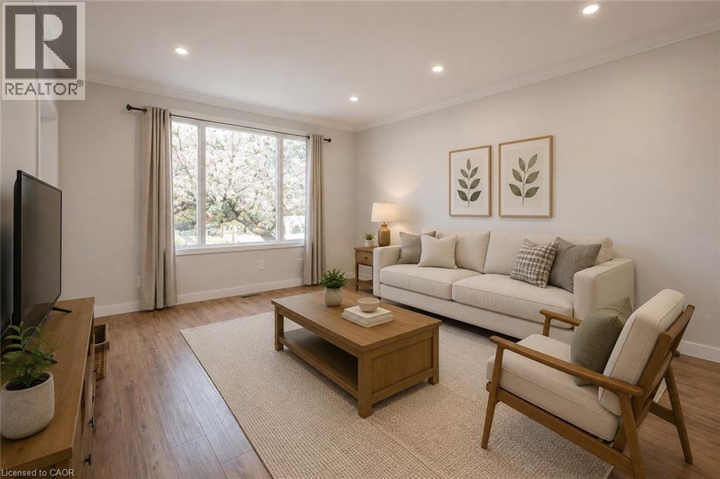 Living space featuring wood-finish flooring, recessed lighting, and a large multi-pane window - 204 Glow Avenue Unit# Upper, Hamilton, ON