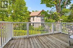 Spacious outdoor deck featuring natural wood planks and white balusters -