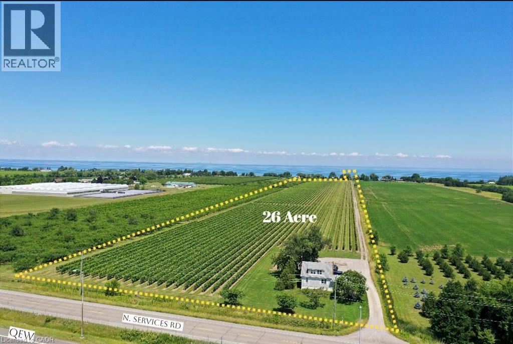 26-acre property featuring vineyard rows, a residential structure, and open green fields - 3705 Service Road N, Beamsville, ON