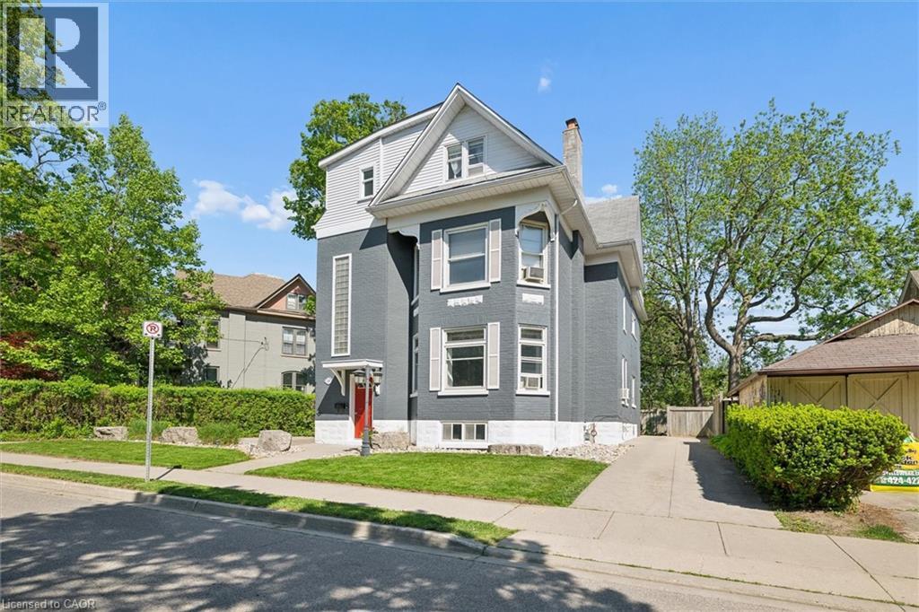 Multi-story residence featuring a gray exterior with white trim, a red entrance door, and a paved driveway - 149 Young Street, Kitchener, ON - Outdoor With Facade