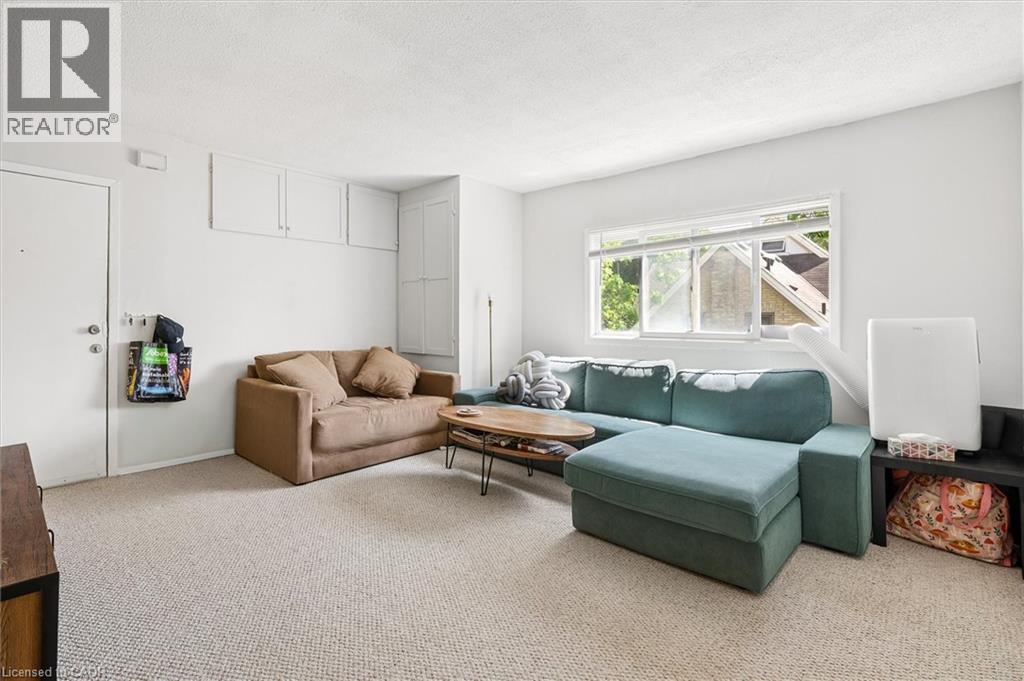 Living area with light-toned carpet flooring and a large window - 149 Young Street, Kitchener, ON - Indoor Photo Showing Living Room