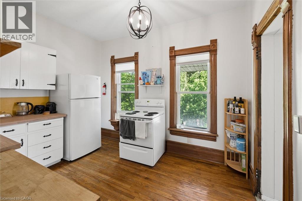 Kitchen featuring white cabinetry, light wood-finish countertops, and matching white appliances - 149 Young Street, Kitchener, ON - Indoor Photo Showing Kitchen