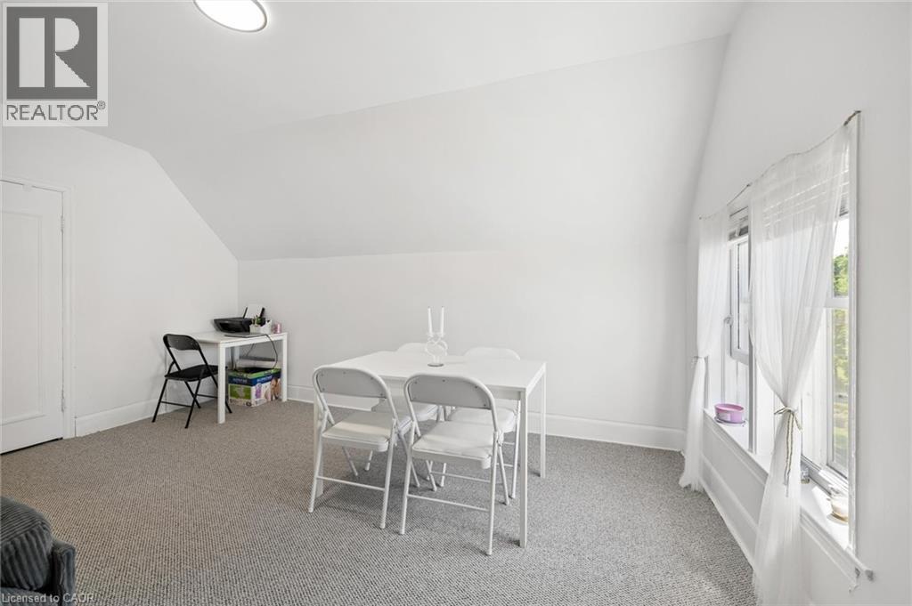 Carpeted room with sloped ceilings and a window featuring white trim - 149 Young Street, Kitchener, ON - Indoor