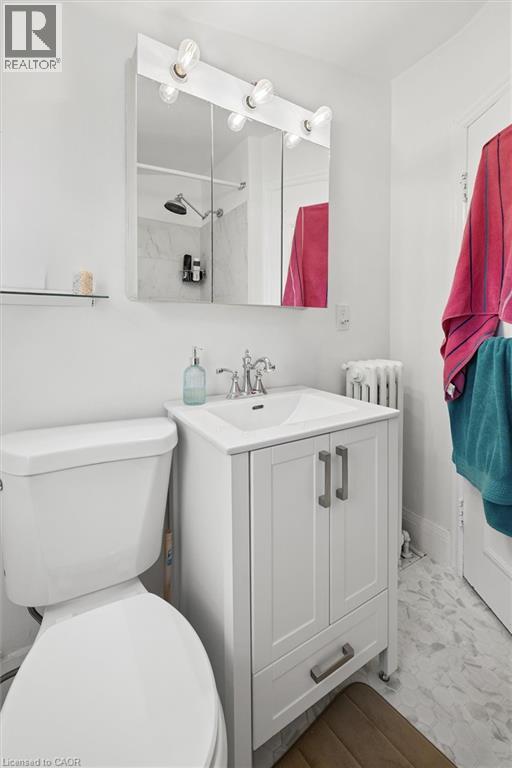 White vanity with integrated sink, chrome faucet, and cabinet storage - 149 Young Street, Kitchener, ON - Indoor Photo Showing Bathroom