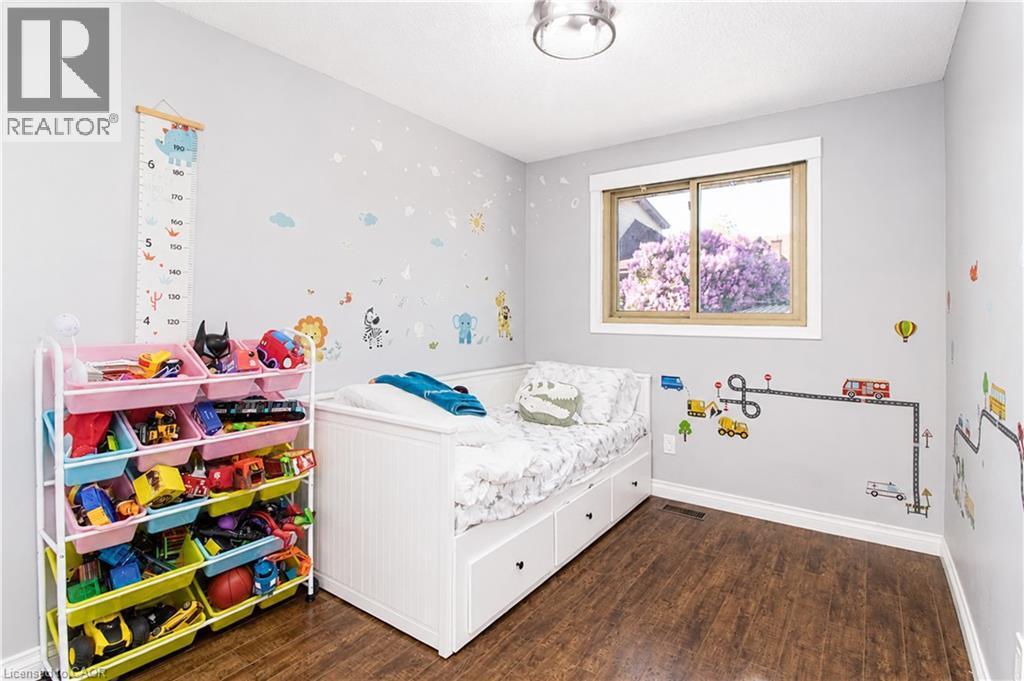 Bright room with wood-finish flooring, a single window, and a flush-mount ceiling light fixture - 103 Mcanulty Boulevard Unit# Upper, Hamilton, ON