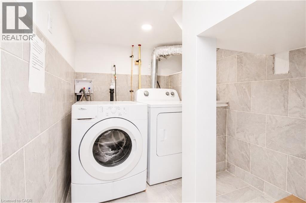 Dedicated laundry area featuring a front-loading washer and top-loading dryer - 103 Mcanulty Boulevard Unit# Upper, Hamilton, ON