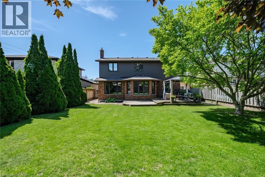 Expansive green lawn with mature perimeter trees and a fenced boundary - 141 Lynndale Road, Simcoe, ON
