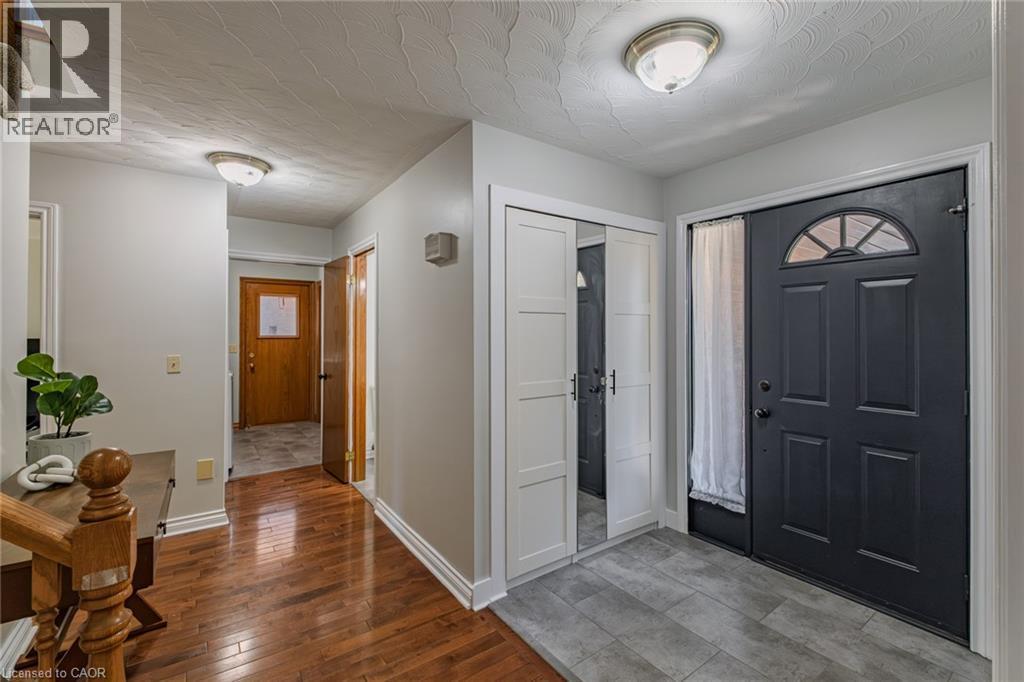 Entryway with dark paneled front door featuring an arched window detail and sidelight - 141 Lynndale Road, Simcoe, ON