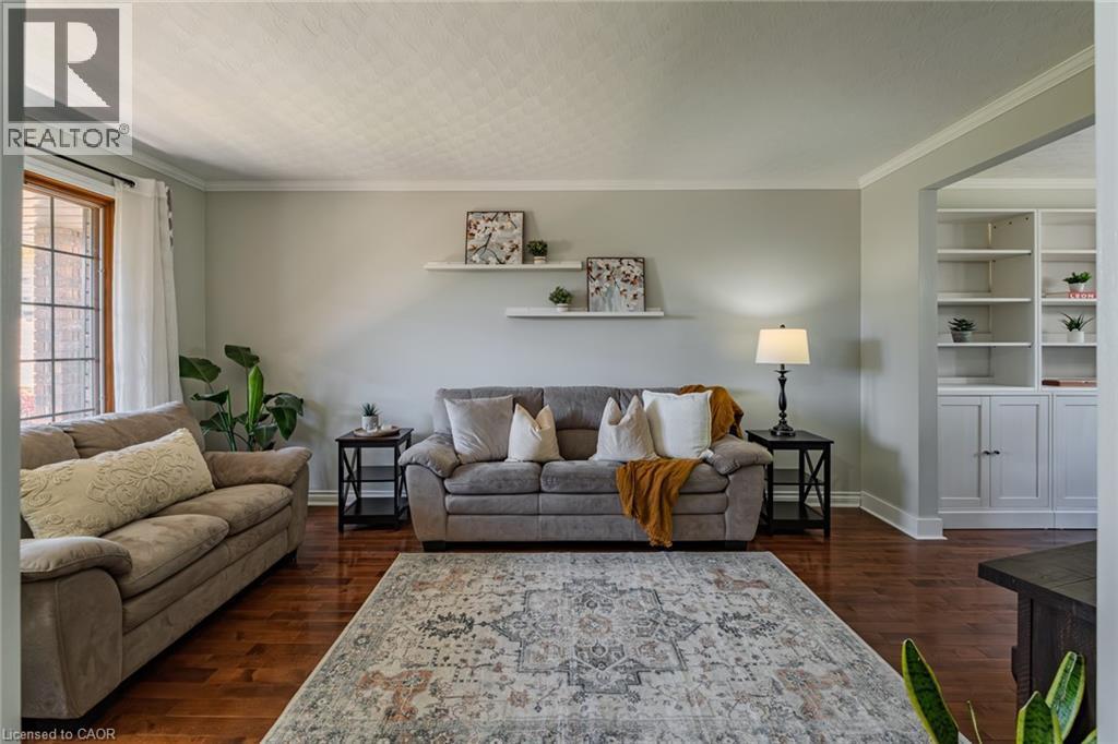 Living area featuring wood-finish flooring, light grey wall tones, and white crown molding - 141 Lynndale Road, Simcoe, ON