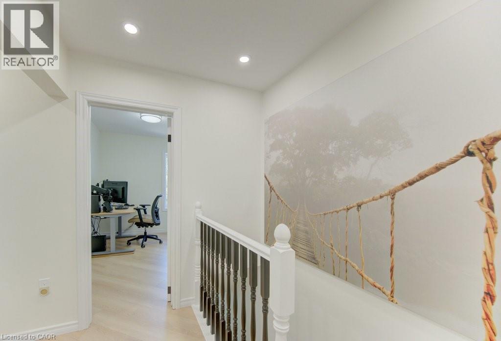 Hallway featuring recessed lighting, a decorative wall mural, and a white painted railing with dark balusters - 11 Davidson Street, Cambridge, ON
