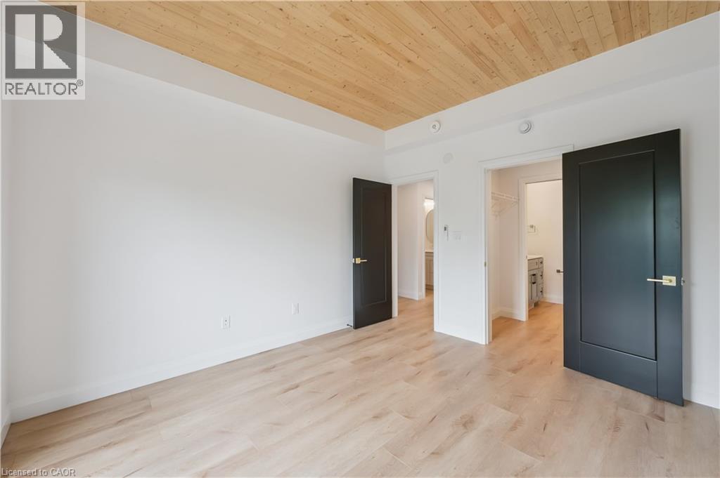 Spacious room featuring wood-finish flooring, white walls, and a natural wood plank ceiling - 60 Arlington Boulevard Unit# 3, Kitchener, ON