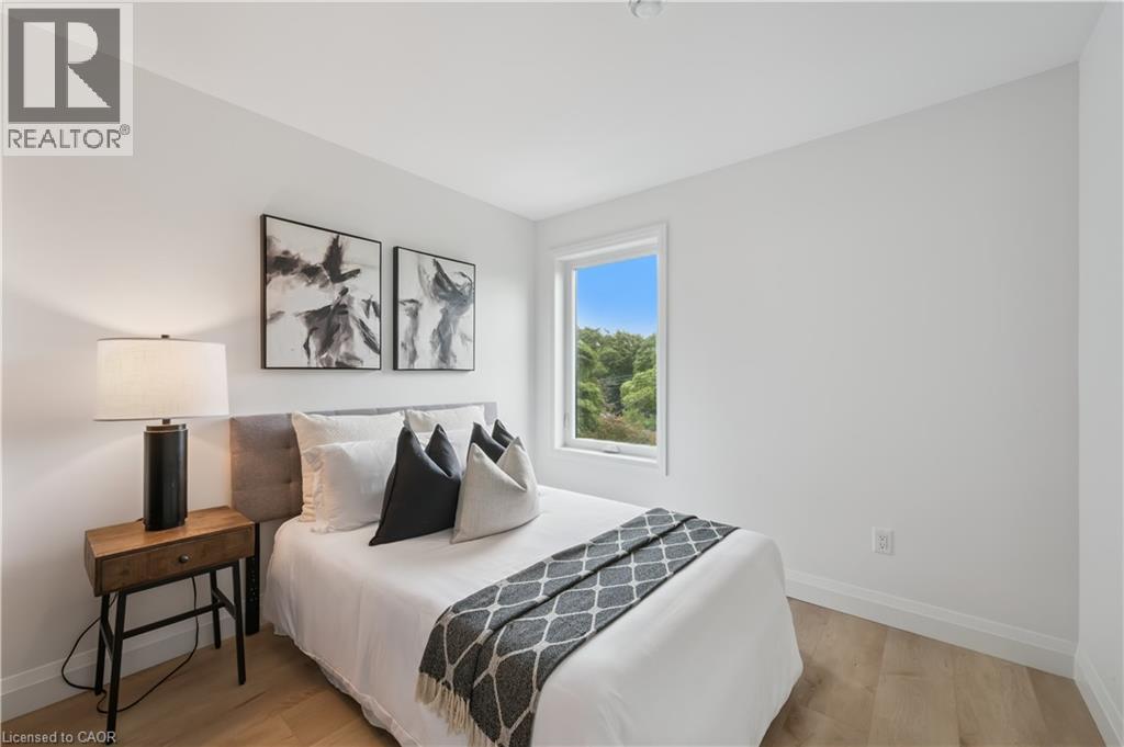 Bedroom featuring light wood-finish flooring, white walls, and a window offering a natural backdrop - 60 Arlington Boulevard Unit# 3, Kitchener, ON
