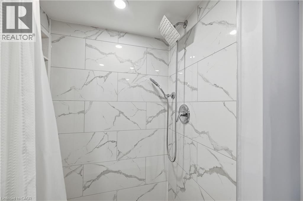 Shower with large format marble-look tile, rainfall showerhead, and handheld shower sprayer - 18 Ipswich Place, Hamilton, ON