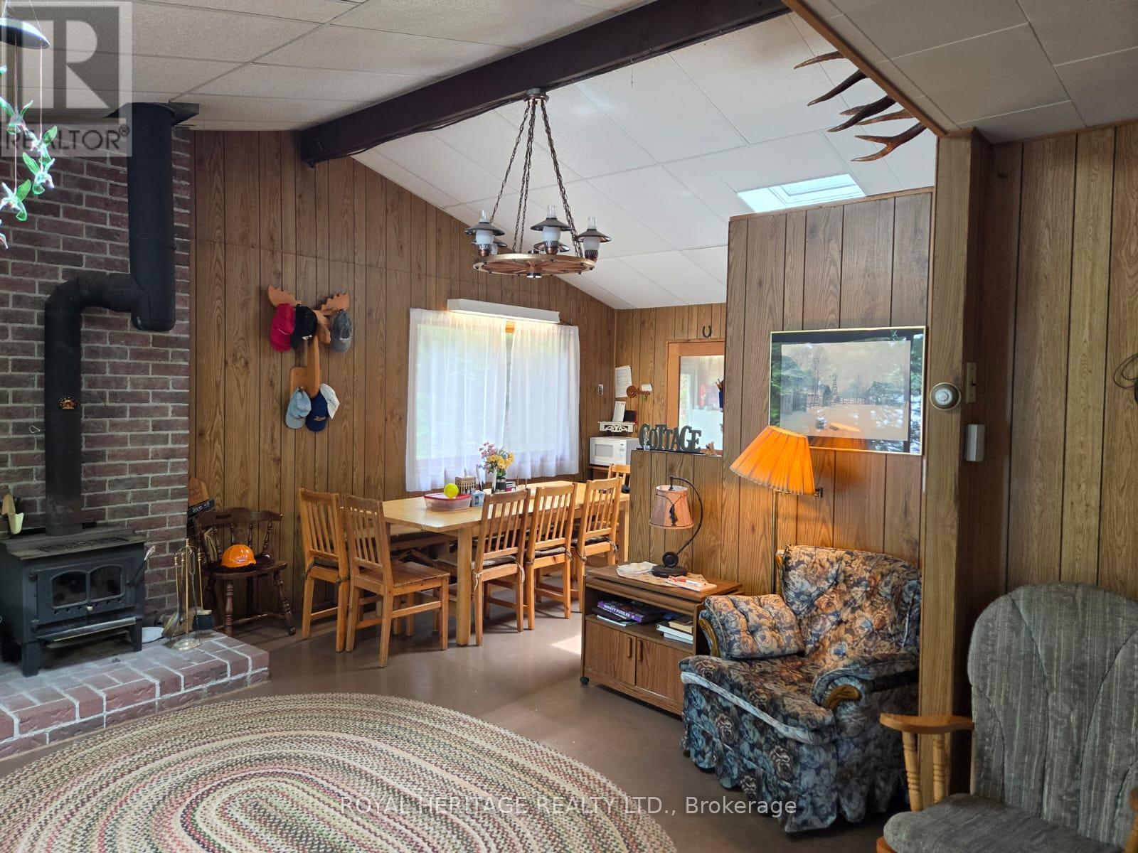 **Cottage Has Vaulted Ceiling With Two Skylights** - 1160 Sunset Strip Lane, Frontenac, ON - Indoor With Fireplace
