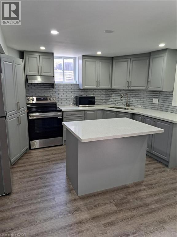 Contemporary kitchen featuring light gray cabinetry, white countertops, a subway tile backsplash, and wood-finish flooring - 2240 Headon Road Unit# Lower, Burlington, ON