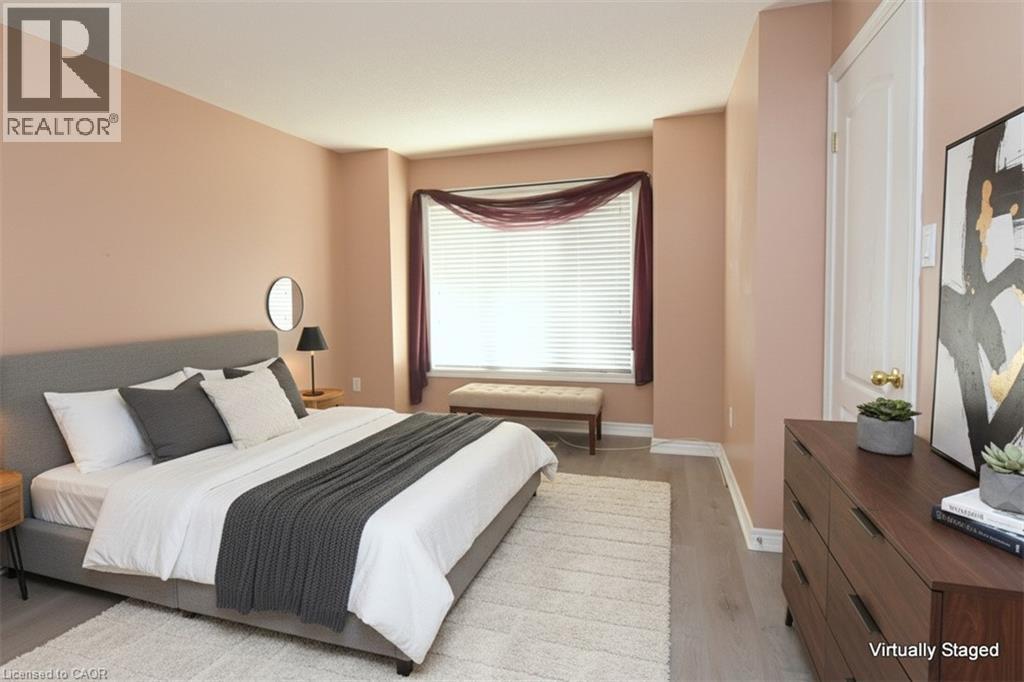 Spacious room featuring wood-finish flooring, light-colored walls, and a large window with horizontal blinds - 2 Harbour Drive Unit# 17, Stoney Creek, ON
