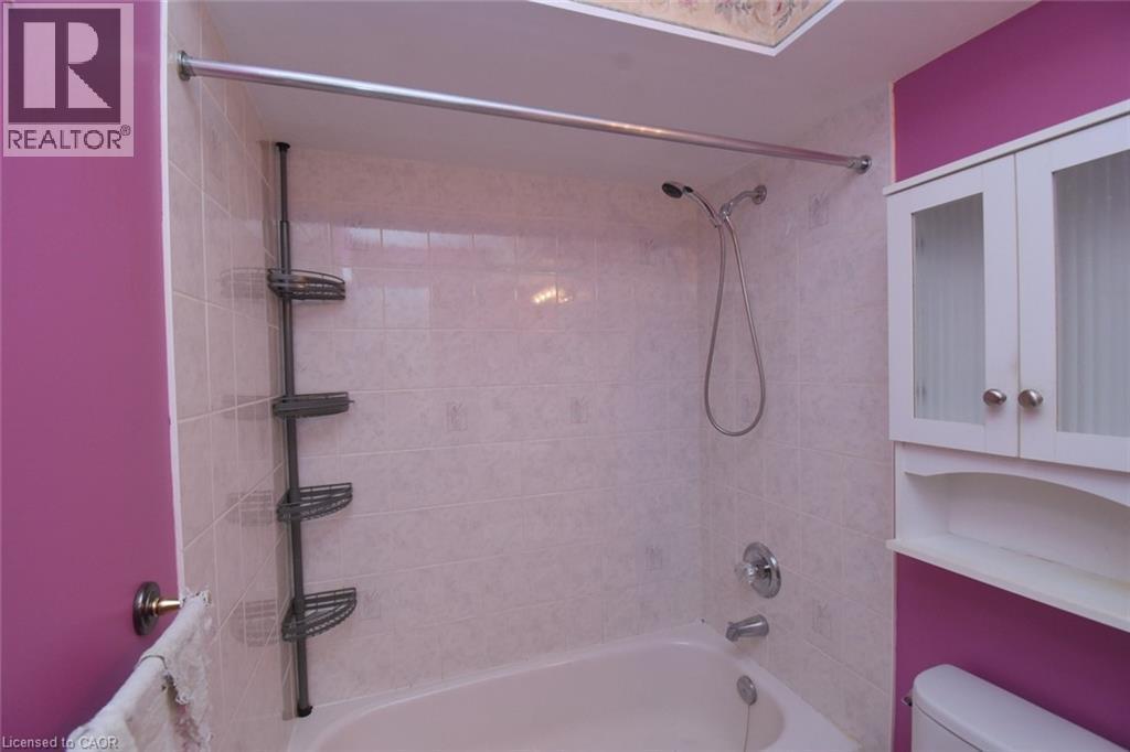 Tub-shower combination featuring white tile surround and chrome fixtures - 2 Harbour Drive Unit# 17, Stoney Creek, ON