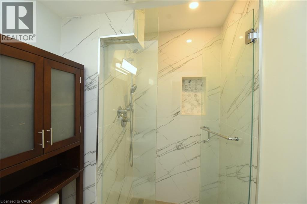 Glass-enclosed shower with a recessed niche featuring mosaic tile - 2 Harbour Drive Unit# 17, Stoney Creek, ON