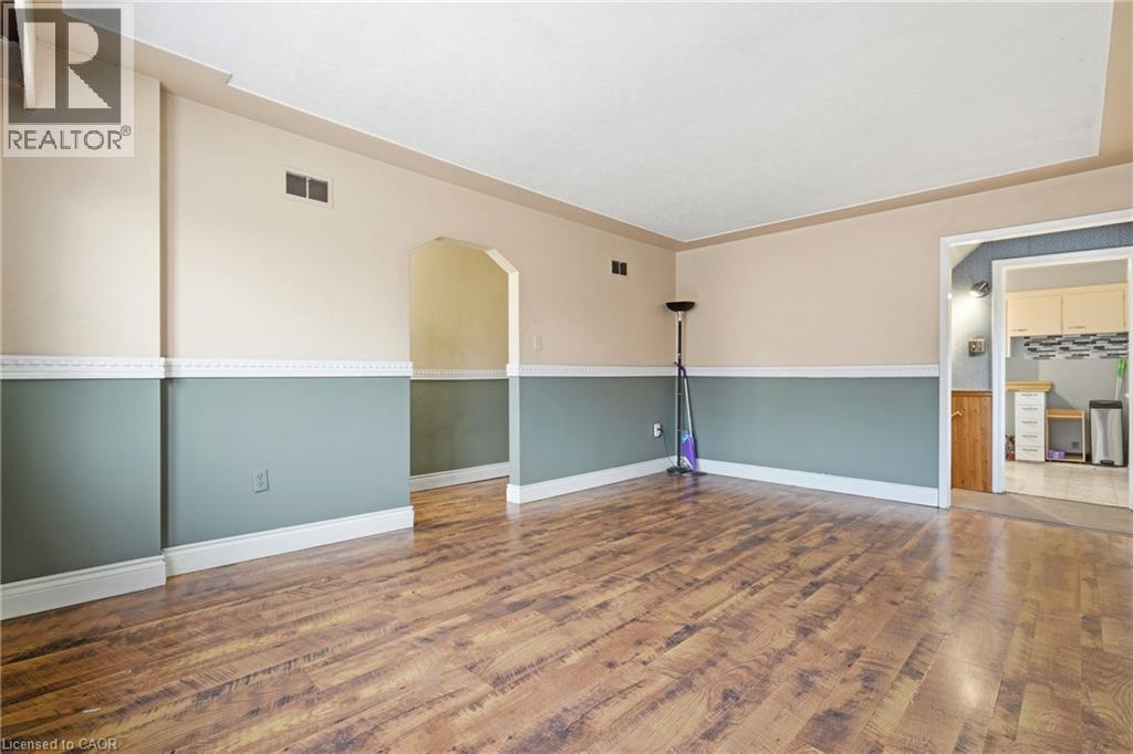 Living room featuring arched walkways and wood finished floors - 549 Weber Street E, Kitchener, ON