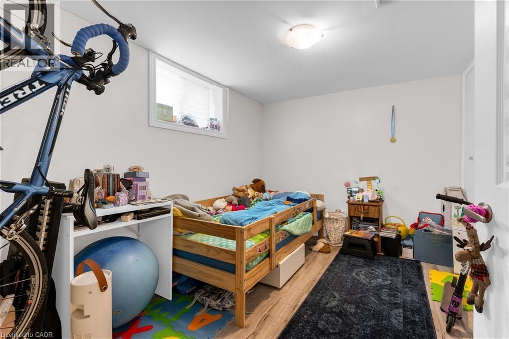 Lower-level room with wood-finish flooring, white walls, and a single window - 406 East 43Rd Street, Hamilton, ON