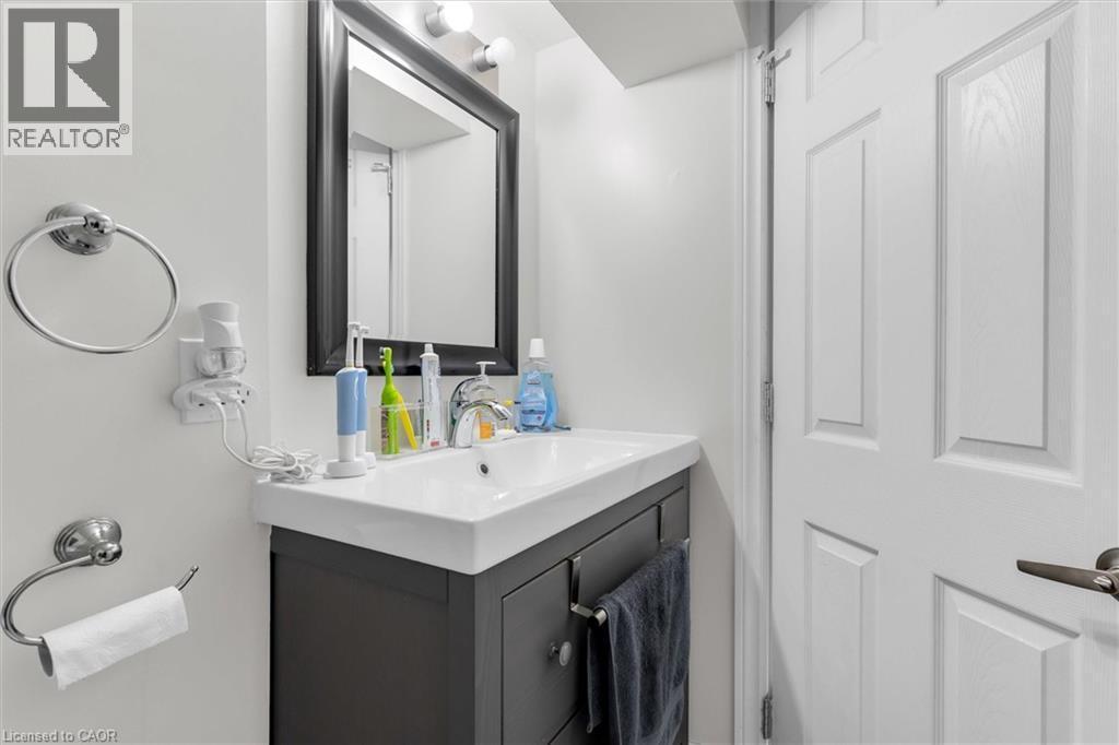 Bathroom featuring a rectangular sink set into a dark gray vanity with chrome hardware - 406 East 43Rd Street, Hamilton, ON