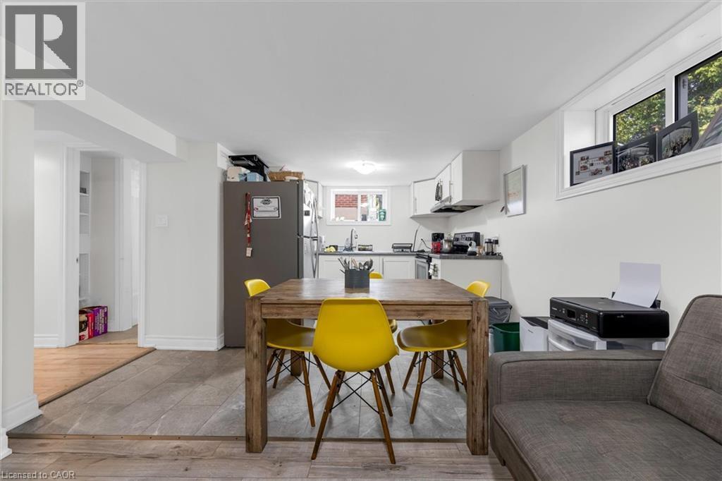 Open-concept living area featuring wood-finish flooring, white walls, and recessed lighting - 406 East 43Rd Street, Hamilton, ON