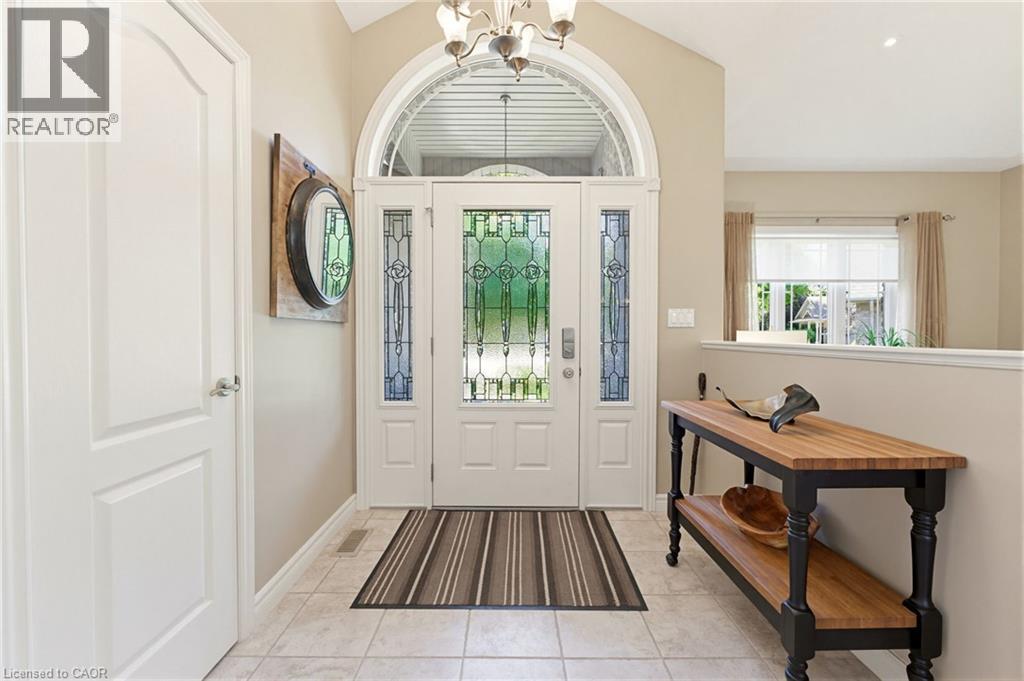 Foyer featuring a grand arched transom window, leaded glass sidelights, and a decorative chandelier - 5 Coastal Court, Port Dover, ON