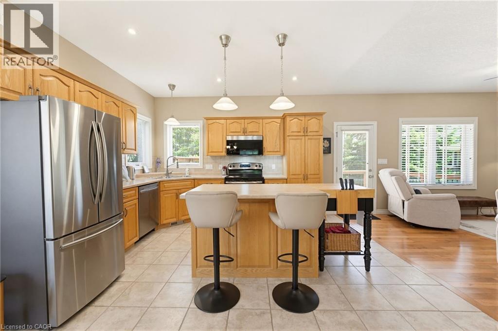 Kitchen featuring wood cabinetry, stainless steel appliances, and a central island with bar seating - 5 Coastal Court, Port Dover, ON