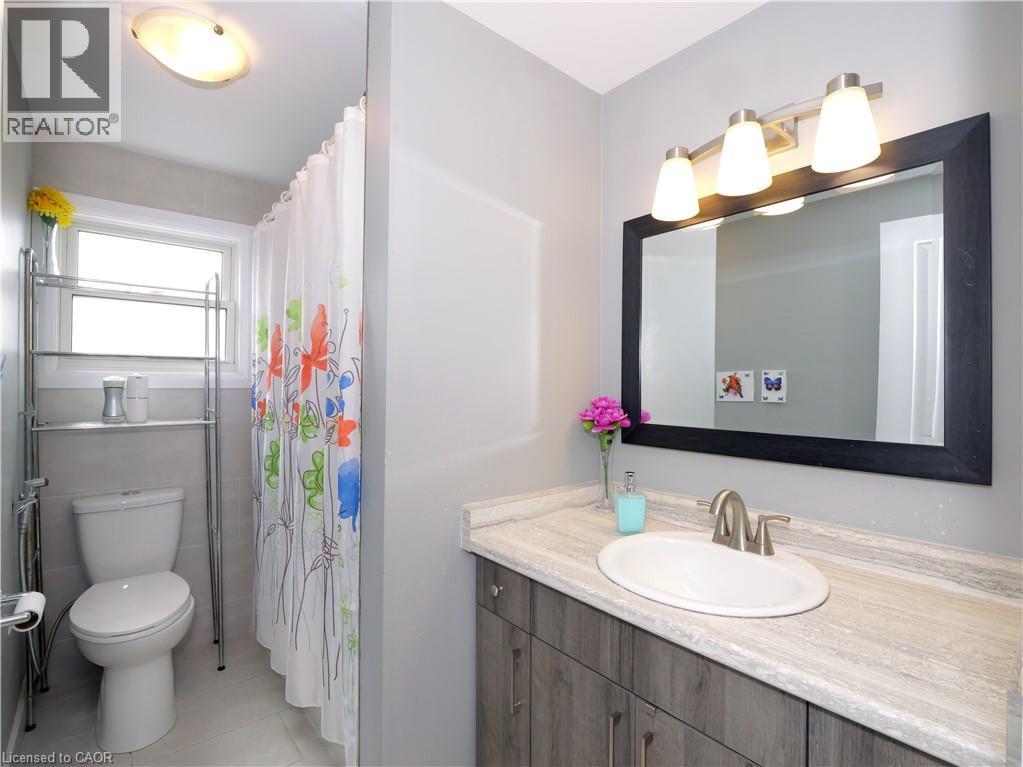 Bathroom featuring a vanity with a light wood-finish cabinet and a stone-look countertop - 771 Monsarrat Avenue, London, ON