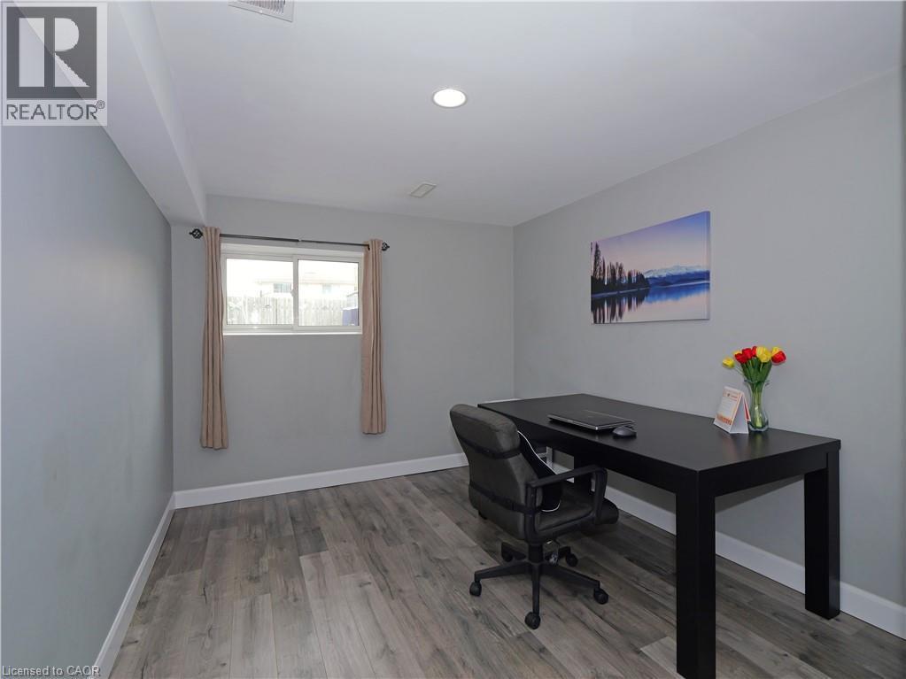 Room featuring light gray walls, wood-finish flooring, a window with a white frame, and a recessed ceiling light - 771 Monsarrat Avenue, London, ON
