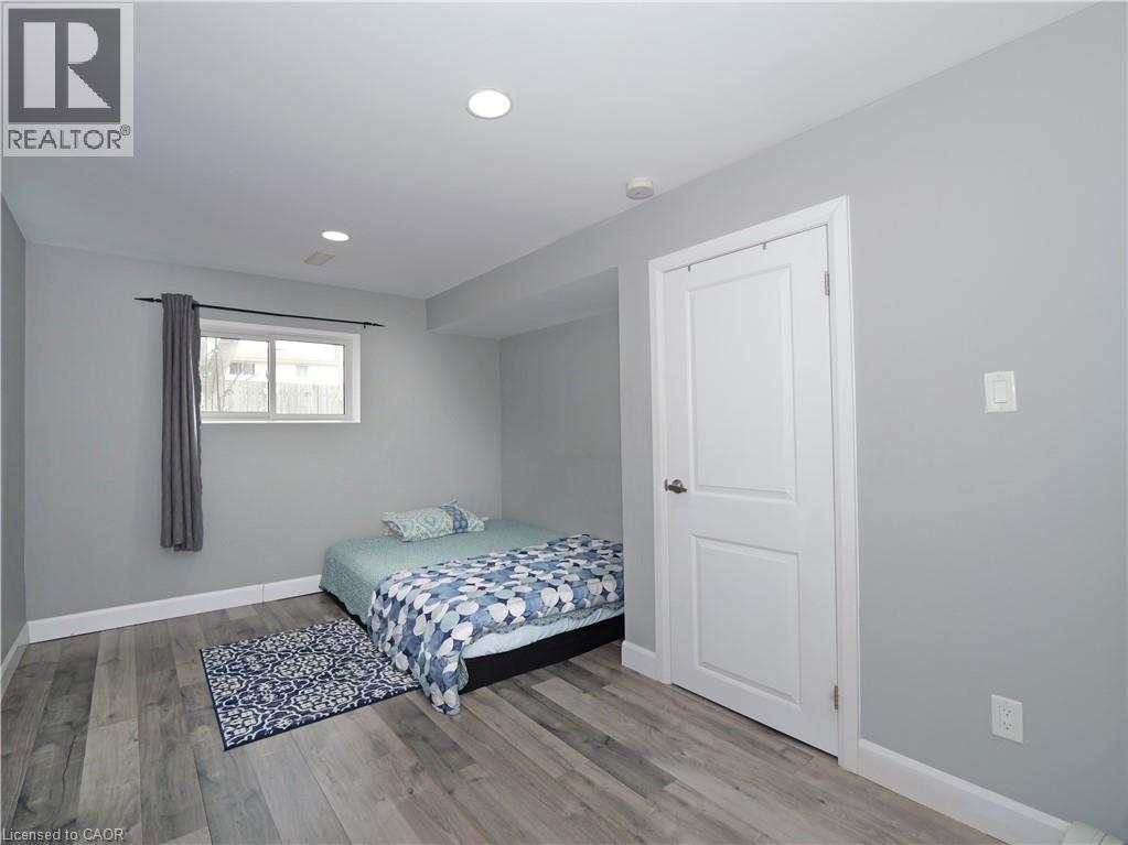 Room featuring wood-finish flooring, recessed lighting, and a white paneled door - 771 Monsarrat Avenue, London, ON