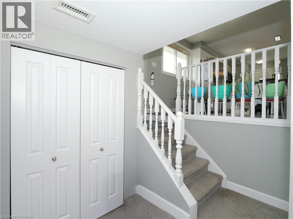 Interior staircase with carpeting and white balusters - 771 Monsarrat Avenue, London, ON