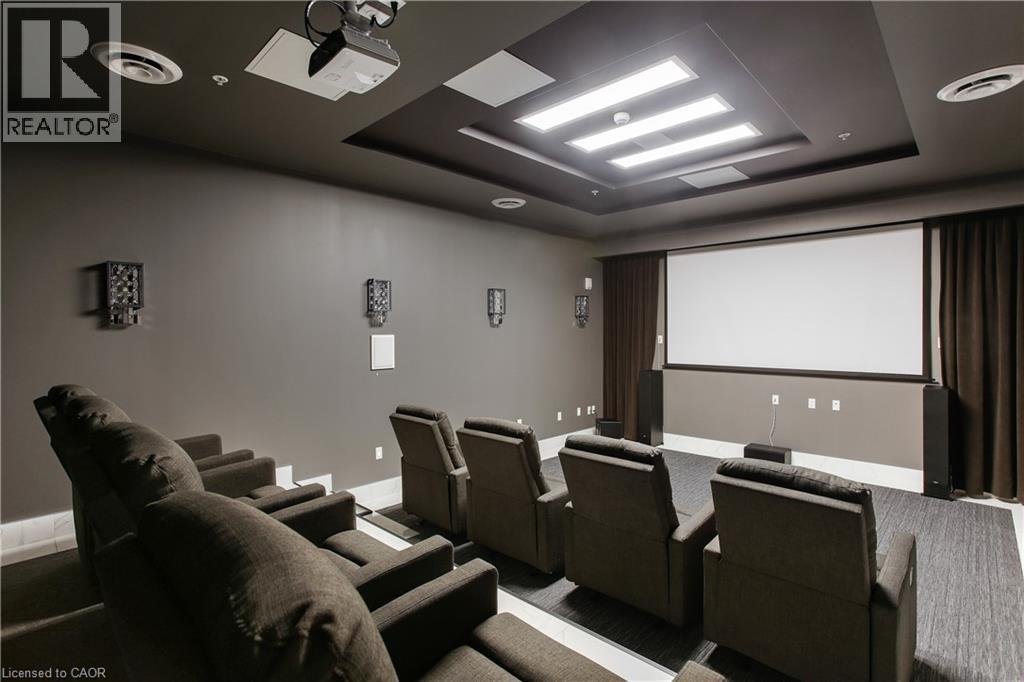 Dedicated media room featuring tiered seating, a large projection screen, built-in projector, integrated wall speakers, and recessed ceiling lighting - 112 King Street E Unit# Ph6, Hamilton, ON - Indoor Photo Showing Other Room