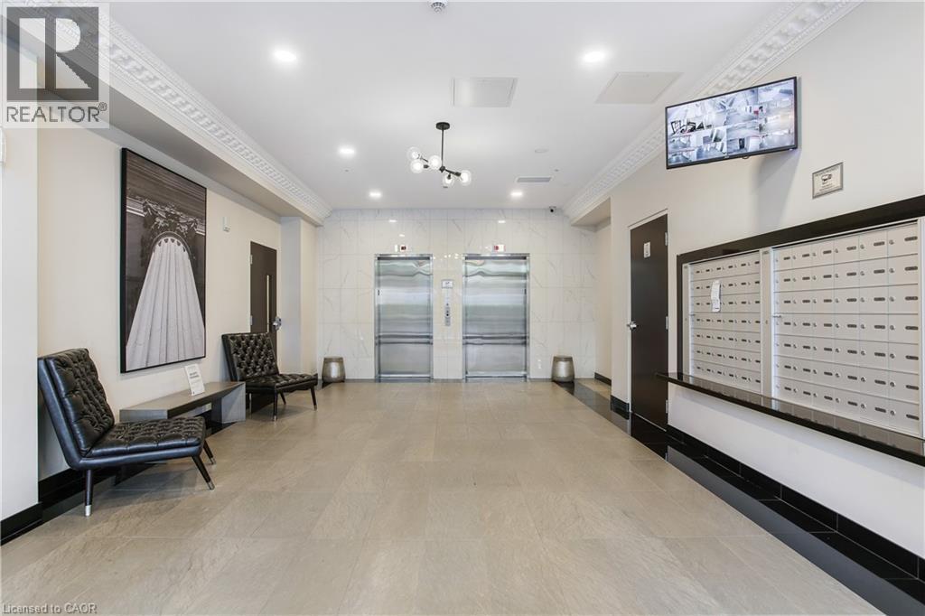 Lobby area featuring two stainless steel elevators, individual mailboxes, and a neutral tile floor - 112 King Street E Unit# Ph6, Hamilton, ON - Indoor Photo Showing Other Room