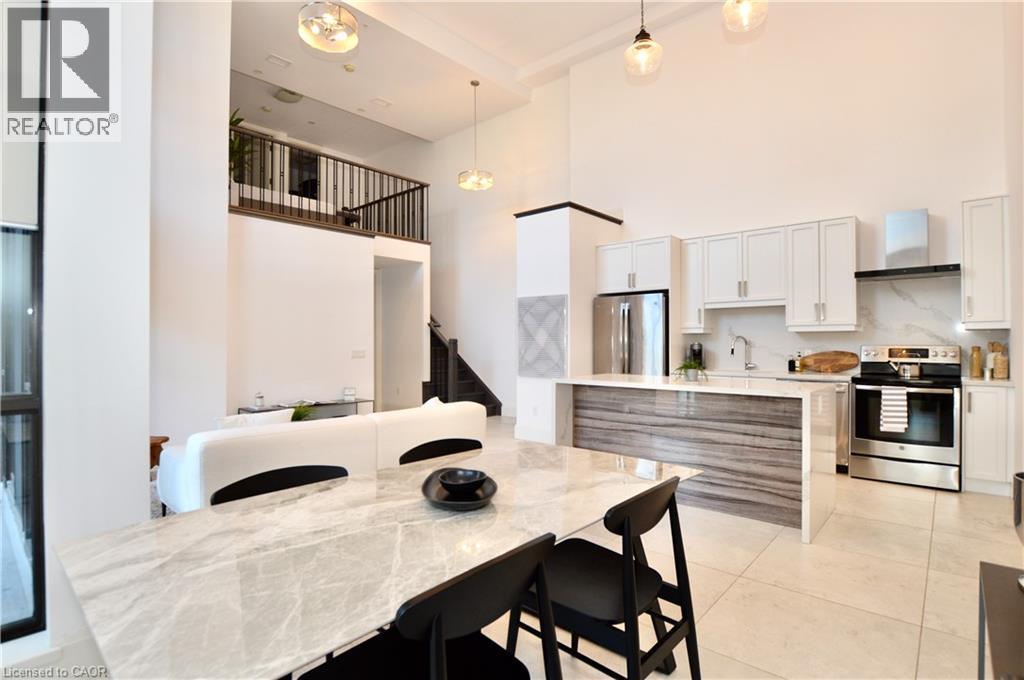 Open-concept living area featuring a two-story ceiling, recessed lighting, and large format tile flooring - 112 King Street E Unit# Ph6, Hamilton, ON - Indoor Photo Showing Kitchen
