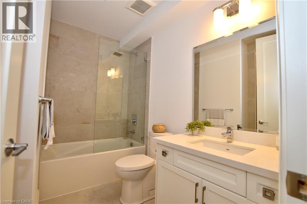 Bathroom featuring a white vanity with an integrated sink, polished chrome faucet, and quartz countertop - 112 King Street E Unit# Ph6, Hamilton, ON - Indoor Photo Showing Bathroom