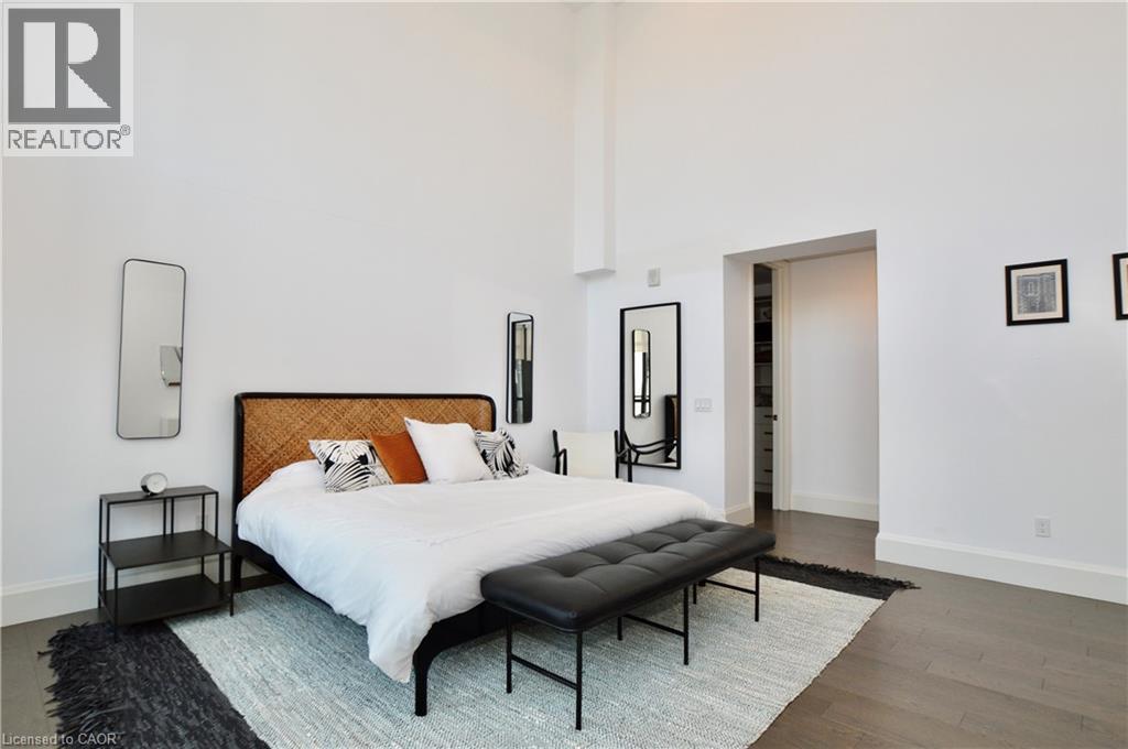 Spacious room with high ceilings, dark wood-finish flooring, and white baseboards - 112 King Street E Unit# Ph6, Hamilton, ON - Indoor Photo Showing Bedroom