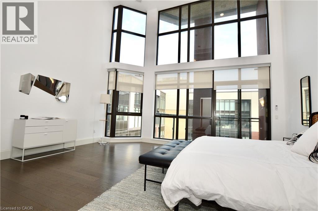 Vaulted ceilings in an interior space featuring tall, multi-pane windows with dark framing - 112 King Street E Unit# Ph6, Hamilton, ON - Indoor Photo Showing Bedroom
