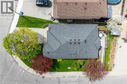 Gable roofline property featuring a corner lot, mature trees, manicured green space, paved driveway, and a rear deck - 50 Spadara Drive, Hamilton, ON - Outdoor