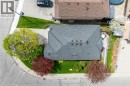 Gable roofline property featuring a corner lot, mature trees, manicured green space, paved driveway, and a rear deck - 50 Spadara Drive, Hamilton, ON  - Outdoor 