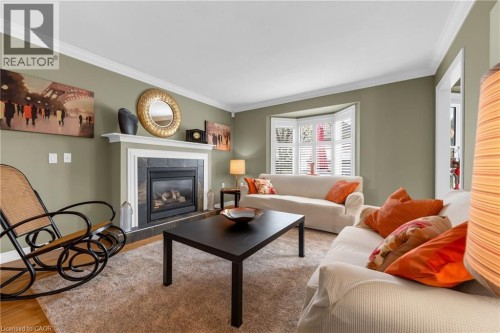 Living area featuring a gas fireplace with a stone surround and white mantel - 50 Spadara Drive, Hamilton, ON - Indoor Photo Showing Living Room With Fireplace
