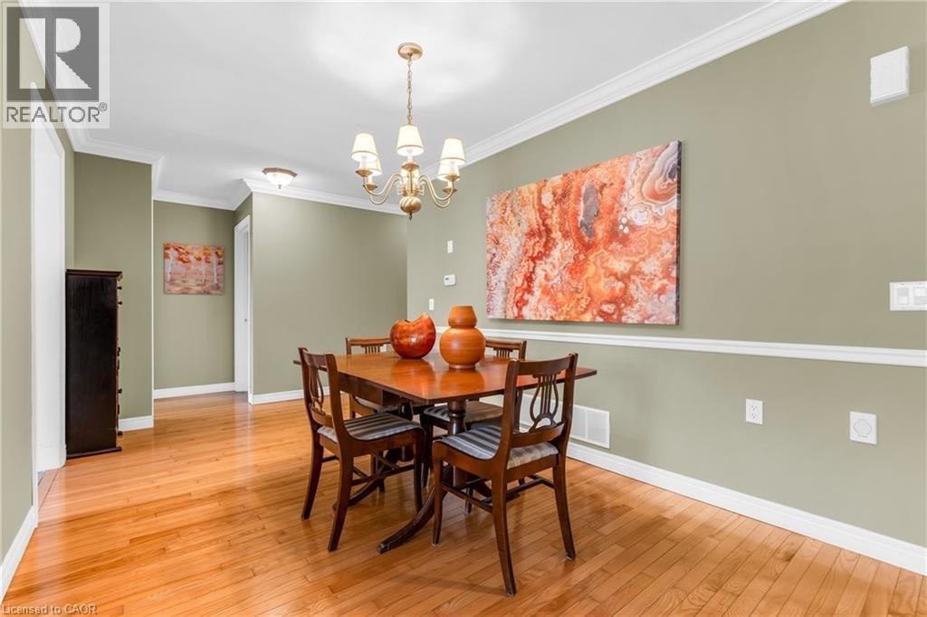 Dining area featuring wood-finish flooring, crown molding, and chair rail detailing - 50 Spadara Drive, Hamilton, ON - Indoor Photo Showing Dining Room